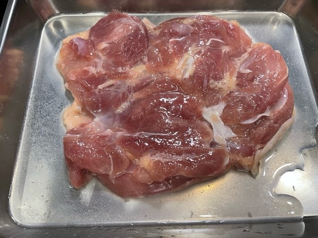 肉に酒をかけて塩を揉みこむ