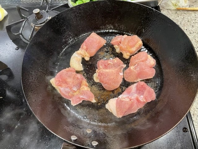 塩コショウをして鶏肉を焼く